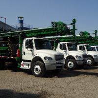 Four Exploration Drill Masters 33K series drill rigs on trucks