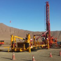 Exploration Drill Masters Rod Feeder with Schramm drill rig in the field.