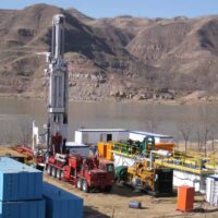 Schramm T200XD drill rig on-site next to a lake.