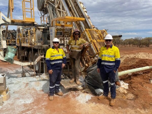 Three workers in the field next to drilling equipment pertaining to Schramm Value-add services.